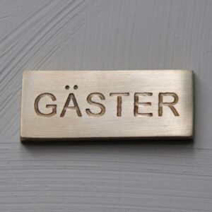 Skylt gäster mässing